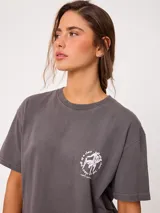 Remera de algodón color amarillo claro, con corte suelto y estampado gráfico en la espalda con diseño de muebles de playa y textos.