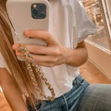 Llavero para celular con cuentas facetadas color amarillo y cuentas plateadas.