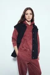 Buzo canguro color marrón oscuro con efecto lavado, calce relajado, capucha integrada, bolsillo frontal tipo canguro y terminaciones clásicas en puños y ruedo.