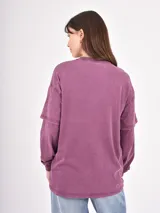Remera de manga larga color bordó con efecto lavado, diseño de doble manga y estampado de estrellas en tono más claro en el frente.