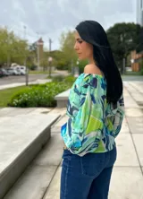 Blusa con estampado abstracto en tonos celeste, verde y azul, con escote off-shoulder, mangas abullonadas 3/4 con lazo y cintura elastizada con lazo.