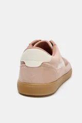 Zapatillas deportivas de estilo retro, confeccionadas en una combinación de gamuza en tonos rosados y detalles en cuero sintético blanco. Presentan cierre mediante cordones al tono y suela de goma plana en color caramelo.
