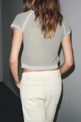 Top de punto gris claro con cuello redondo y manga corta, presentando un efecto degradado o desteñido en el cuello, hombros y ruedo.