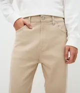 Pantalón de sarga de algodón con acabado vintage, corte recto y ajuste cómodo. Presenta cierre frontal con botón y cremallera, pasadores para cinturón y bolsillos funcionales en la parte delantera y trasera.