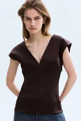 Top de sarga con leve brillo color marrón, con escote en V pronunciado, manga japonesa y costuras moldeadoras delanteras y traseras.
