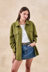 Sobrecamisa verde militar de lino y viscosa, corte oversize, con cuello camisero, cierre frontal con botones, mangas largas con puños abotonados, dos bolsillos de parche con solapa en el pecho y ruedo recto.