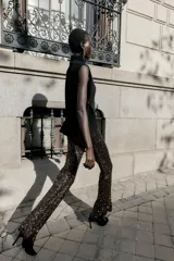 Top de punto color verde militar, con cuello subido y manga sisa. Presenta apliques dorados en los laterales y un bajo asimétrico.