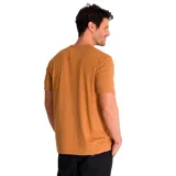 Remera color ocre de algodón, con cuello redondo y mangas cortas. Estampa frontal con el logo de Caterpillar y el dibujo de una máquina excavadora. Corte clásico.