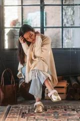 Pantuflas de corderito color blanco, ideales para usar en casa.