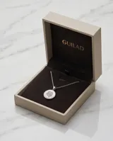 Collar de cadena fina de plata 925 con dije circular de nácar y diseño central de trébol de cuatro hojas con incrustaciones de circonias.