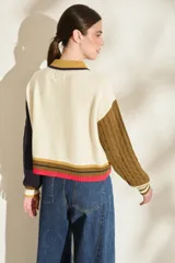Cardigan de punto con diseño tricolor, de corte relajado, manga larga de tejido trenzado en contraste de color, cuello solapa tipo polo y cierre frontal de botones.