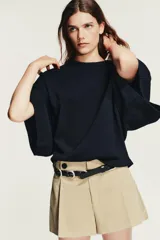 Cinturón de piel negro de 2,5 cm de ancho, con múltiples hebillas metálicas plateadas y cierre de hebilla.