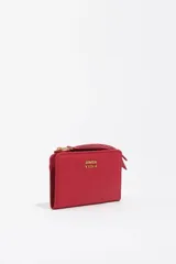 Billetera de estructura blanda confeccionada en nylon color rojo, con cierre de cremallera y tirador de tejido con el nombre de la marca. Presenta logo metálico dorado en el frente, tarjetero interior y forro con logo grabado.