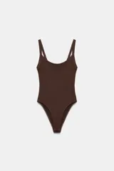 Body de cuello cuadrado con tirantes finos, confeccionado en tejido elástico con cierre inferior mediante botones a presión.