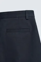 Bermuda de hombre color azul marino, de corte relajado (relaxed fit), confeccionada en tejido con textura. Presenta bolsillos frontales y bolsillos traseros de vivo, con cierre frontal de cremallera y botón.