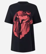 Remera de algodón color negro, con cuello redondo, manga corta y estampa frontal geométrica en color rojo inspirada en el logo de The Rolling Stones.