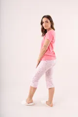 Pijama de dos piezas color coral, compuesto por una remera de manga corta con botones y un pantalón capri estampado con flores.