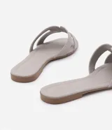 Sandalias planas Satinato de color tostado, con diseño de tiras cruzadas en forma de H en el empeine y puntera cuadrada.
