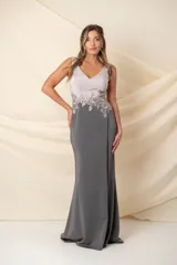 Vestido largo de fiesta, confeccionado en crepé de seda combinado en gris grafito y color nude. Presenta corsé con aplique bordado en hilo de seda con detalle de brillo en la cintura y falda con abertura lateral.