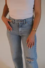 Jean celeste de tiro alto, corte wide leg y rotura en la rodilla.