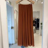 Pantalón fluido terracota de tiro alto, con cintura elastizada y diseño plisado de perneras anchas.
