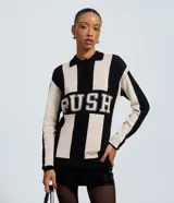 Buzo oversized de punto jacquard con diseño de rayas verticales en contraste. Presenta cuello polo con cierre de botones frontal y estampado con lettering 'RUSH' en el pecho. De corte amplio y manga larga.