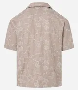 Camisa de poliéster color beige con bordado floral blanco, de corte regular, cuello inglés, manga corta y abotonada en el frente.