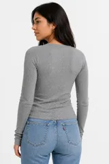Remera de manga larga en tejido acanalado, con cuello redondo y ajuste al cuerpo.
