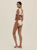 Conjunto de bikini color rosa pálido con estampado de cebras marrones. El corpiño es de corte triangular con banda inferior marrón y la bombacha es de tiro alto con cintura marrón.