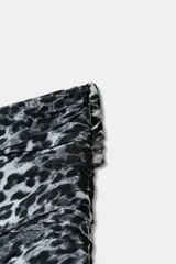 Minifalda con estampado animal print de leopardo en tonos blanco y negro. Presenta tiro medio, cintura fruncida y volantes en el ruedo.