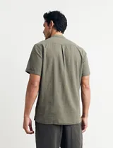 Camisa de manga corta con cuello mao y cierre frontal parcial con botones de coco. Confeccionada en una mezcla de lino y algodón.