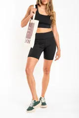 Short tipo biker de tiro alto, confeccionado en tejido técnico elástico de secado rápido, con costuras reforzadas y bolsillos laterales integrados.