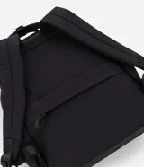 Mochila negra con bolsillo delantero con cierre, bolsillo interno para notebook, correa de mano y asa para valija.