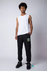 Pantalón jogger de corte oversize confeccionado en tela rústica color verde agua claro. Presenta una estampa gráfica localizada en el muslo izquierdo con diseño de óvalos y estrellas.