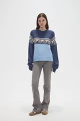 Sweater de tejido de punto con diseño jacquard, cuello redondo y mangas largas. Presenta una combinación de bloques de color azul marino y celeste con un patrón geométrico en la parte superior.