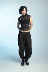 Pantalón parachute negro de corte holgado, con cintura elastizada y cordones ajustables en los tobillos.
