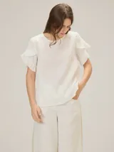 Blusa de lino color rosado, de corte recto y holgado, con cuello redondo y mangas cortas adornadas con volados.