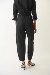 Pantalón jean slouchy negro de tiro medio, con silueta relajada, bolsillos laterales y traseros, y leve entalle en los tobillos.