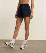 Bermuda deportiva corta de microfibra ligera, color lila, con cintura elástica funcional y textura de agueros.