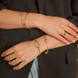 Pulsera de malla extensible en oro amarillo y blanco de 18k, con detalle de esfera central pulida.