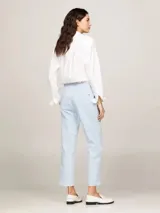 Pantalón chino celeste de corte recto y slim fit, con cierre de cremallera y botón, bolsillos delanteros de parche y logo de Tommy Hilfiger bordado en la parte trasera.