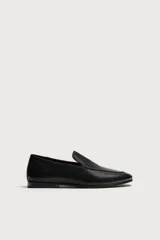 Mocasín de cuero negro con diseño liso, detalle de bordón en el empeine, horma redonda y suela ultrafina.