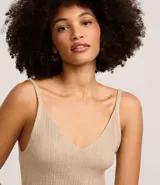 Blusa musculosa de punto canelado con hilo metalizado, escote en V y tirantes finos. Presenta un acabado brillante y un ajuste al cuerpo.