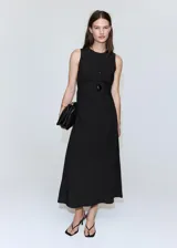 Vestido midi negro sin mangas, con cuello redondo y diseño recto con sutil frunce en los laterales de la cintura.