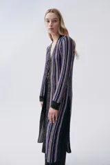 Sacón largo de tejido de punto con rayas verticales en tonos azul, rosa, amarillo y negro. Tiene mangas largas, cuello en V y cierre frontal con lazos.