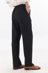 Pantalón de vestir gris oscuro, de corte recto y relajado, con cintura elastizada, cierre de cremallera y botón. Cuenta con bolsillos laterales.