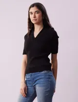 Buzo azul de tejido acanalado, con cuello solapa y escote en V en tejido calado.