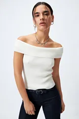 Top tejido de punto acanalado color blanco, con escote bardot que deja los hombros al descubierto.