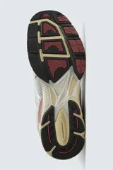 Zapatilla deportiva tipo running con diseño técnico, confeccionada en una combinación de materiales sintéticos y malla. Presenta una estética metalizada en tonos plata con detalles en color granate y una suela con volumen de diseño irregular en tono crema.
