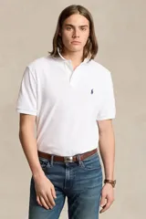 Remera polo Ralph Lauren de corte clásico, confeccionada en algodón piqué blanco, con cuello acanalado, cierre frontal de dos botones y el logo del jugador de polo bordado en azul en el pecho.
